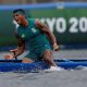 Sentado na canoa, mas com as pernas na água, Isaquias, vestido de verde, solta um grito após ganhar o ouro