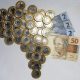 Moedas de R$ 1 formam o mapa do Brasil; do lado direito, há três notas de R$ 2 e uma de R$ 50