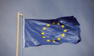 Bandeira da União Europeia em um lastro. Ao fundo, céu nublado
