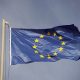 Bandeira da União Europeia em um lastro. Ao fundo, céu nublado